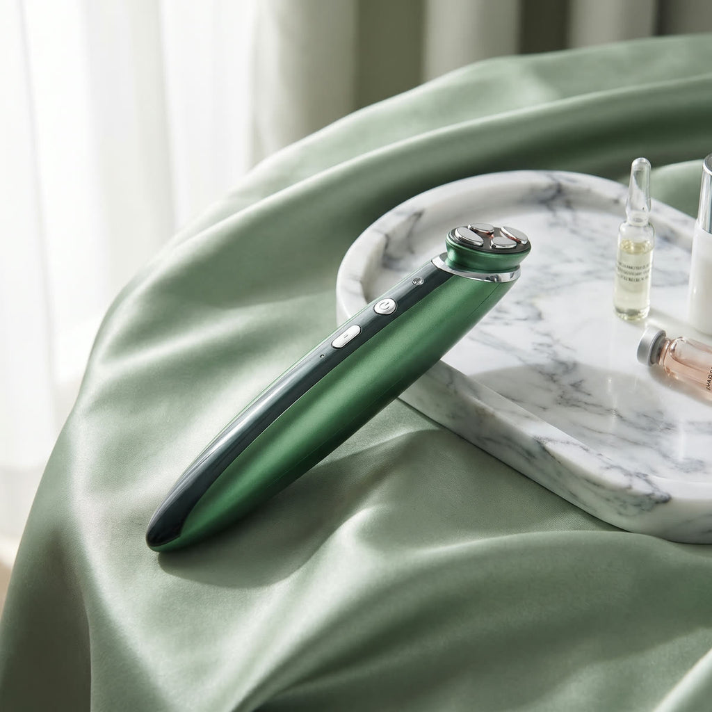 GlowEye Augenmassagegerät in Grün auf Marmorschale